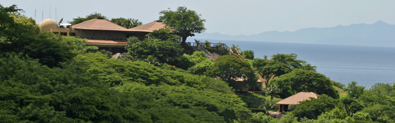 Panoramic view of Ocotal Beach Resort, showcasing the club house, rich vegetation, hidden duplex villas, and the scenic bay embraced by mountains.