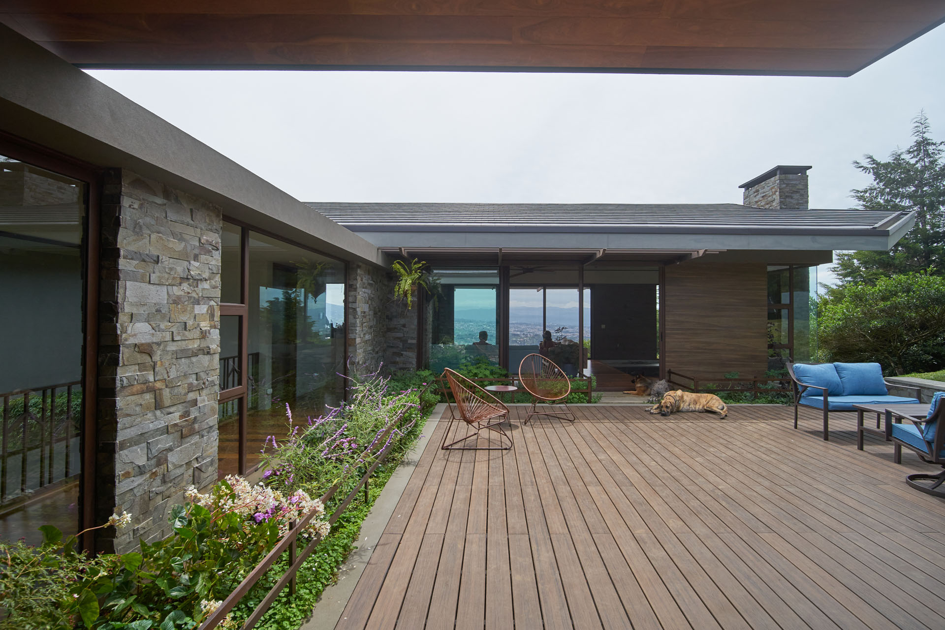 Outdoor deck at Musdan Estate enclosed by stone walls and operable glass.