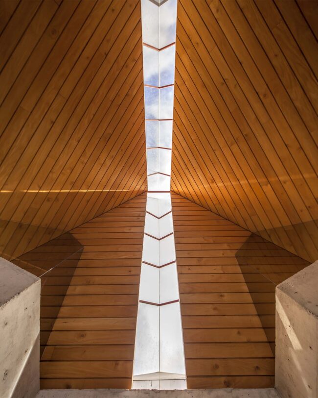 Square, symmetrical view of Soto House's pyramid roof, a prime example of Costa Rican architecture, highlighting wooden ceilings divided by the linear glass skylight